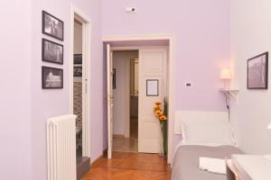um quarto branco com uma cama e um vaso de flores em Colazione Al Vaticano Guest House em Roma