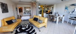 sala de estar con sofá y comedor en Appartement terrasse esprit loft vue sur mer, en Erquy