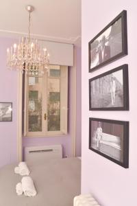 une salle à manger avec un lustre et des photos murales dans l'établissement Colazione Al Vaticano Guest House, à Rome