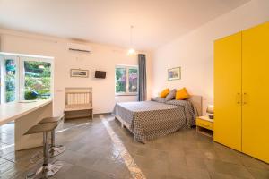 a bedroom with a bed and a yellow cabinet at Casa Mary Family Apartment in Sorrento