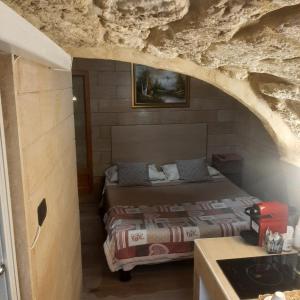 a bedroom with a bed in a stone wall at Il sottano borgo antico in Bari