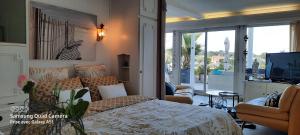 een slaapkamer met een bed en een woonkamer met een televisie bij Appartement terrasse esprit loft vue sur mer in Erquy