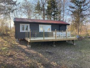 een tiny house met een veranda en een terras bij Sjövillan 2 in Stallarholmen