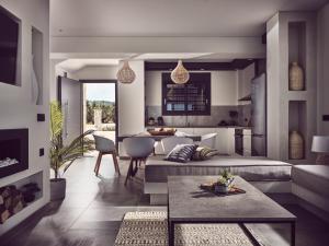 a living room with a couch and a table at LaMer SeaFront Villa, Zante Zen By ThinkVilla in Kipseli