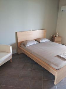 1 cama con cabecero de madera en una habitación en Aggeliki House 3, en Kómboi