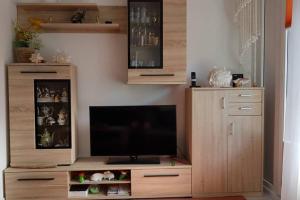 a large wooden entertainment center with a flat screen tv at Ferienwohnung Berolina 116 in Dahme