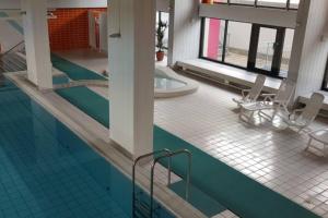 a swimming pool with two chairs and a table at Ferienwohnung Berolina 116 in Dahme