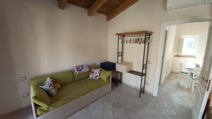 a living room with a green couch and a table at Dimora Igea b&b in Montano Antilia