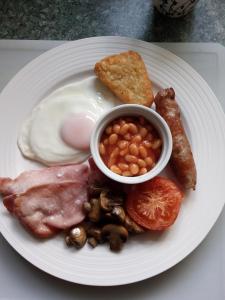 a plate of breakfast food with eggs beans and bacon at Fassfern Guesthouse in Fort William