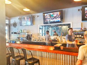 a man standing behind a bar in a restaurant at The Port Hotel and Marina in Crystal River