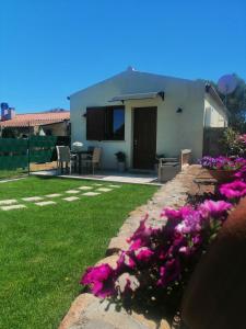 una casa con flores púrpuras en el patio en La LocanDina en Olbia