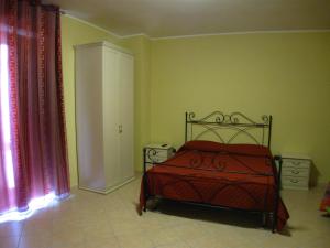 1 dormitorio con 1 cama con colcha roja en B&B Il Vecchio Portale, en Laino Borgo