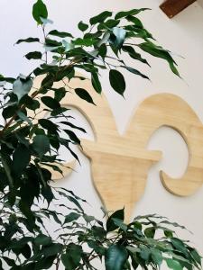 a wooden number on a wall with a plant at Gîte La Grange au Bois in Viella