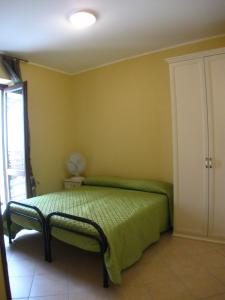 a bedroom with a green bed and a window at B&B Il Vecchio Portale in Laino Borgo
