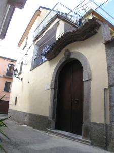 een gebouw met een zwarte deur en een balkon bij B&B Il Vecchio Portale in Laino Borgo
