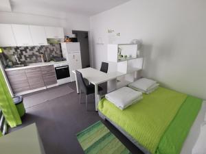a small room with a bed and a desk and a kitchen at Laura's dream Appartments in Pag