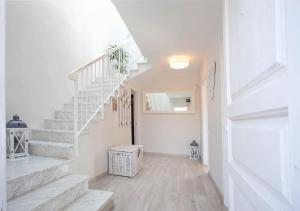a hallway with stairs in a home with white walls at Chillout House with heated pool 29 C Sea & Mountain view in Santa Susanna +22 photos