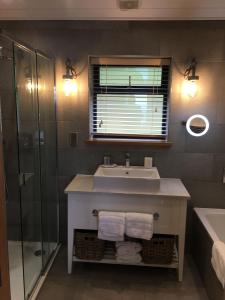 a bathroom with a sink and a shower at 5 Luxury Lodge with beautiful views of the Taf Estuary in Carmarthen
