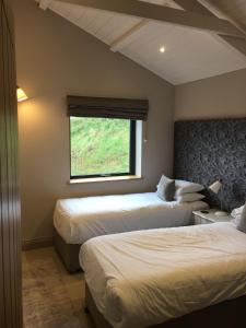 a hotel room with two beds and a window at 5 Luxury Lodge with beautiful views of the Taf Estuary in Carmarthen