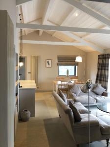 a living room with two couches and a kitchen at 5 Luxury Lodge with beautiful views of the Taf Estuary in Carmarthen