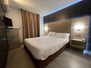a hotel room with a bed and a television at Hôtel L'Escale Coté Port in LʼÎle-Rousse