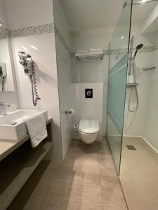 a bathroom with a toilet and a sink and a shower at Hôtel L'Escale Coté Port in LʼÎle-Rousse