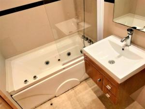 ein Badezimmer mit einem Waschbecken und einer Badewanne neben einem weißen Waschbecken in der Unterkunft ACV - Valparaiso - 2ª linea, planta 3, norte in Oropesa del Mar