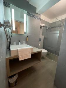a bathroom with a sink and a toilet at Hôtel L'Escale Coté Port in LʼÎle-Rousse