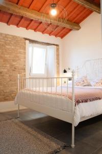 a bedroom with a white bed and a window at La Trave in Montecosaro