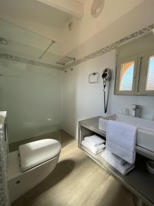 a bathroom with a toilet and a sink at Hôtel L'Escale Coté Port in LʼÎle-Rousse