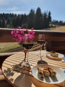 a table with two glasses of wine and some food at Zlatar Luxury Chalet - TRACE OF NATURE 2214 in Nova Varoš