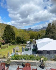 a patio with chairs and a white tent at Aberdunant Hall in Porthmadog