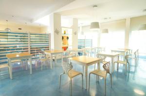 una sala da pranzo con tavoli e sedie di Kalos Hotel a Maruggio