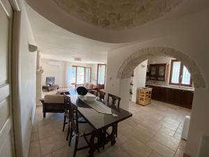 a dining room and living room with a table and chairs at Il Pepe Rosa - Valle D'Itria in Martina Franca