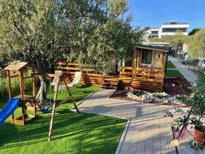 a yard with a playground and a house at Kamp Karla & Bruno in Sveti Filip i Jakov