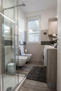 un bagno con doccia, WC e lavandino di Laura's Little Diamond Apartment - Residence Bel Post a Domaso Altre 15 foto