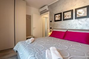 una camera da letto con un grande letto con cuscini rosa di Laura's Little Diamond Apartment - Residence Bel Post a Domaso