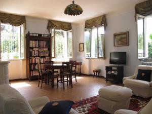 sala de estar con mesa, sillas y ventanas en Porteselago en San Felice del Benaco