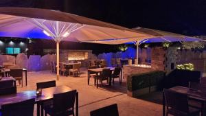 a restaurant with tables and umbrellas at night at Aberdunant Hall in Porthmadog