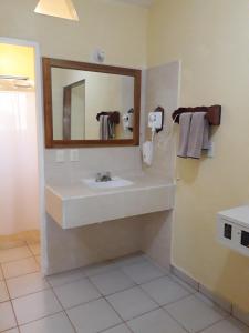 y baño con lavabo y espejo. en Hotel - Museo Xibalba, en Palenque