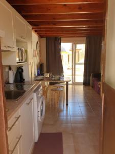 a kitchen with a sink and a table with a washing machine at oasis RELAX Corralejo in Parque Holandes