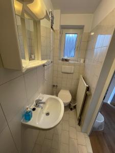 a bathroom with a sink, toilet and tub at Gästehaus zum Surgrund in Cuxhaven