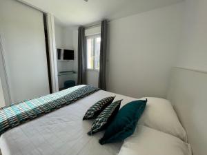 ein Schlafzimmer mit einem Bett mit zwei Kissen darauf in der Unterkunft Residence Des Îles in LʼÎle-Rousse