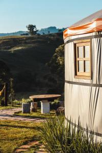 un edificio blanco con ventana y mesa de picnic en Yurt, romântico e luxuoso, natureza e cachoeiras, en Jacutinga