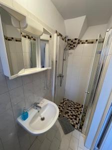 a bathroom with a sink, toilet and shower at Gästehaus zum Surgrund in Cuxhaven