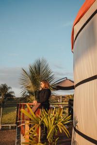 a woman is talking on a cell phone at Yurt, romântico e luxuoso, natureza e cachoeiras in Jacutinga