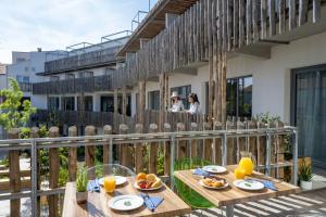 ラ・ロシェルにあるATHOME RESIDENCE ET SPAのバルコニーの上にテーブルと食べ物