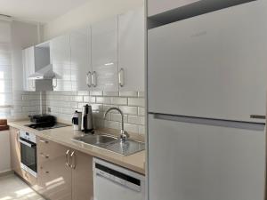 uma cozinha branca com um lavatório e um frigorífico em City Suites em Marmaris