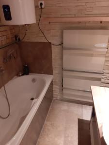 y baño con bañera y lavamanos. en Sarló utcai ház en Veszprém