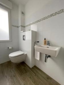 ein weißes Badezimmer mit Toilette und Waschbecken in der Unterkunft Residence Des Îles in LʼÎle-Rousse + 25 Fotos